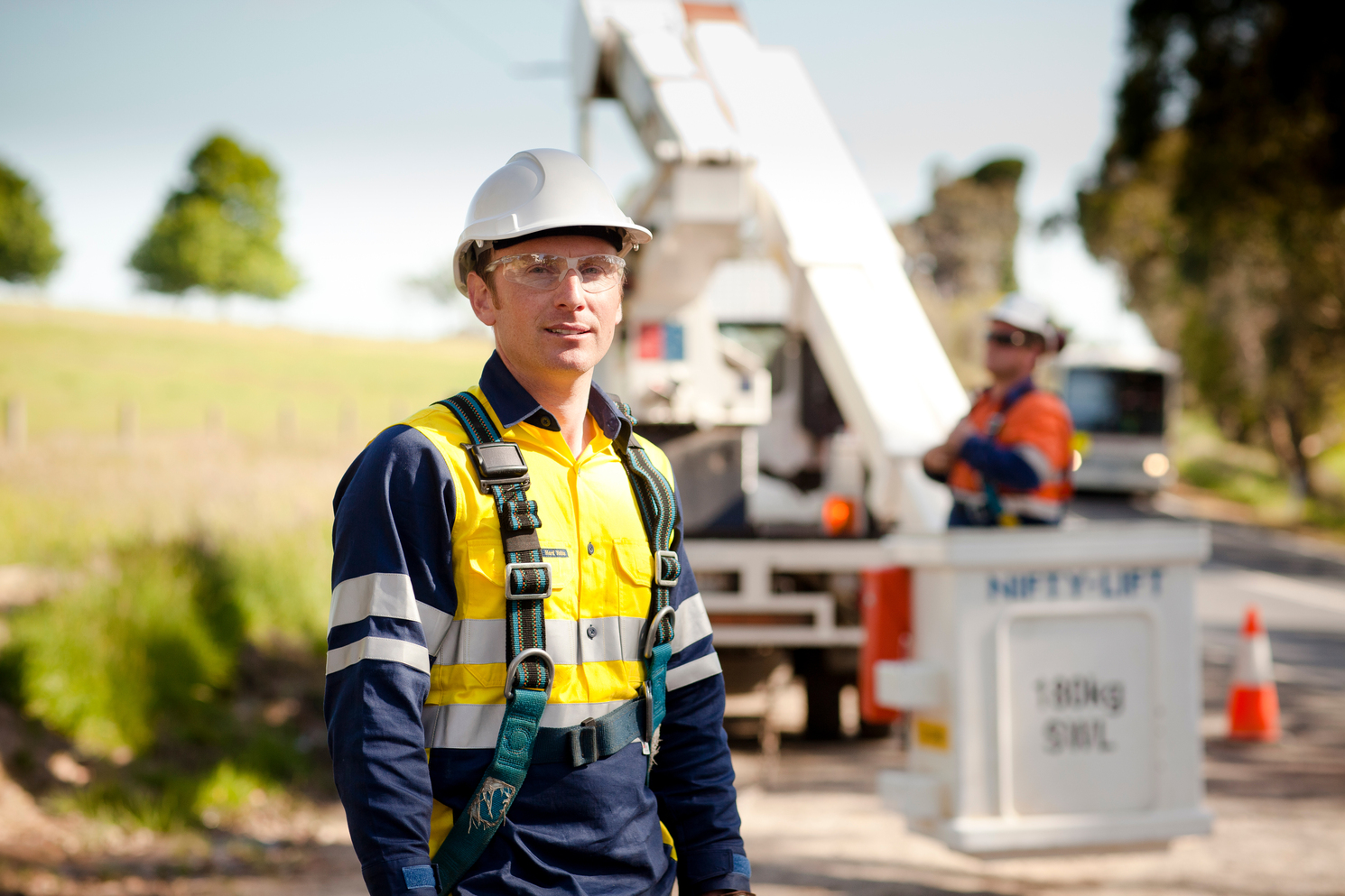 A man in hi-vis standing outside near machinery